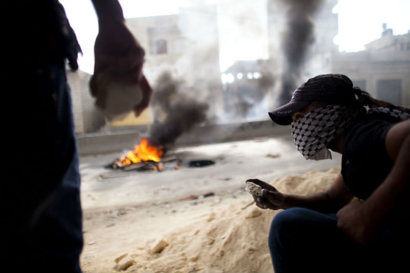 Palestinians burned tires and threw stones during clashes with the Israeli police on 15 May 15 2011 at Qalandiya checkpoint near Ramallah, West Bank. The day marked the 'Nakba' or 'catastrophe' which befell Palestinians following Israel's establishment in 1948. (Photo by Uriel Sinai/Getty Images)