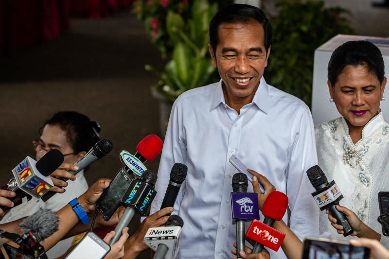 Indonesian President Joko Widodo and his wife Iriana speak to journalists after casting his ballot at a polling station on 17 April 2019 in Jakarta. (Photo by Ulet Ifansasti/Getty Images)