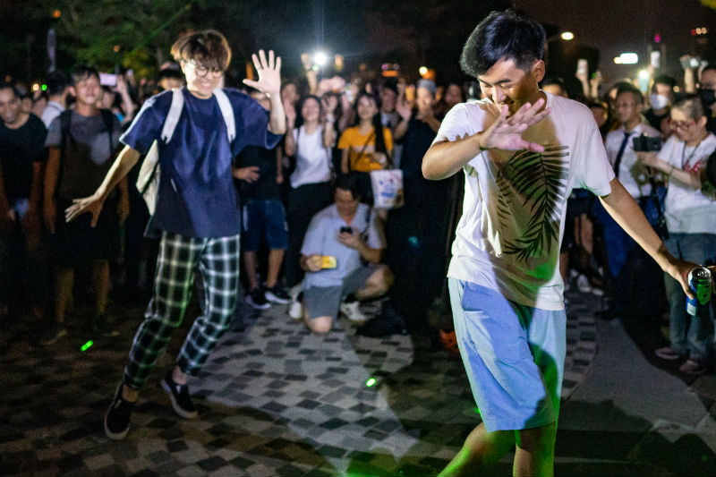 Protesters dance outside the Hong Kong Space Museum during a demonstration on 8 August 2019. Pro-democracy protesters have continued rallies on the streets of Hong Kong against a controversial extradition bill since 9 June as the city plunged into crisis after waves of demonstrations and several violent clashes. Hong Kong's Chief Executive Carrie Lam apologised for introducing the bill and declared it 'dead', however protesters have continued to draw large crowds with demands for Lam's resignation and completely withdraw the bill. (Photo by Anthony Kwan/Getty Images)