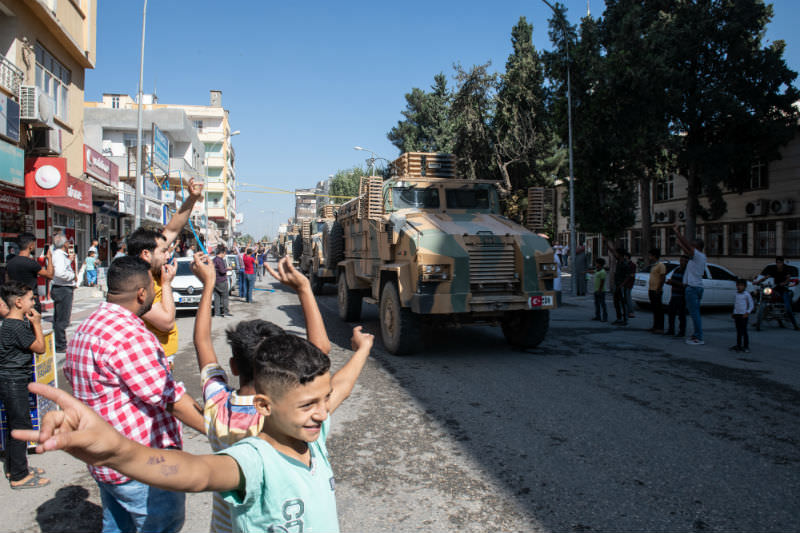 Turkish armoured vehicles escort members of the Turkish-backed Free Syrian Army, a militant group active in parts of northwest Syria, as they enter Syria on 10 October 2019. (Photo by Burak Kara/Getty Images)