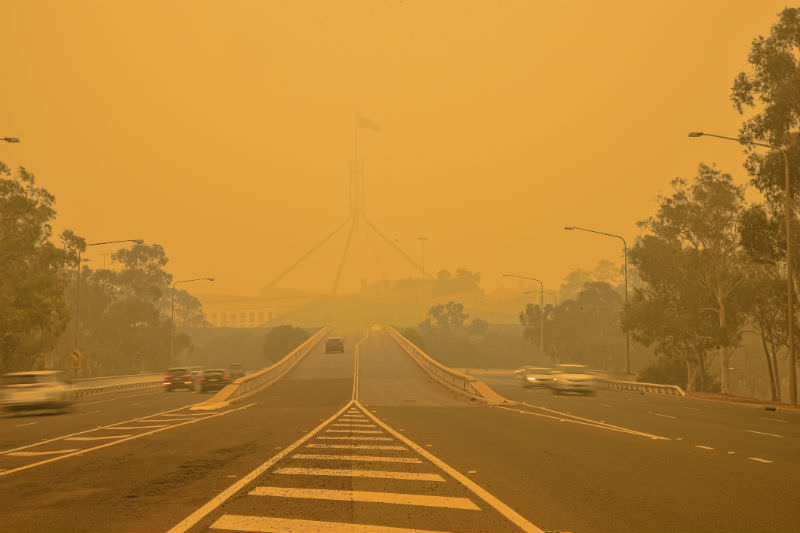 Main image: The Australian Parliament house is hardly visible behind a dense smog. (Photo by Daniiielc/Getty Images)