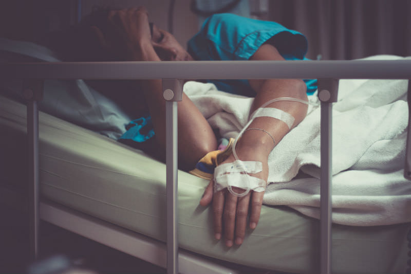 A woman on a hospital bed covers her face (Getty images/ Manop Phimsit)
