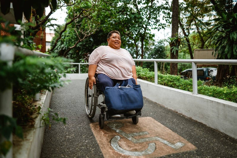 Woman using a wheelchair to go down a ramp (Iya Forbes/Getty Images)