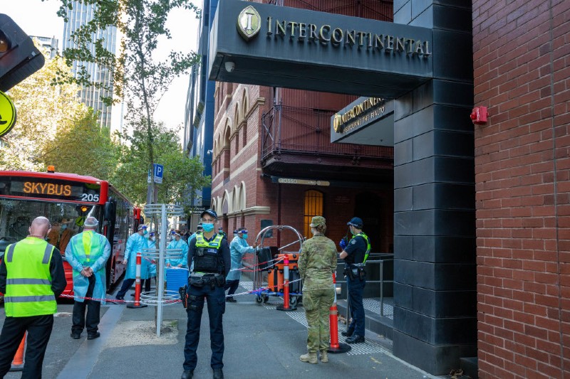 Main image: Police and hotel quarantine workers wearing PPE at the entrance of the Intercontinental Hotel quarantine (Asanka Ratnayake/Getty Images)