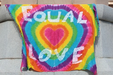 Rainbow coloured banner bearing the slogan 'Equal love'